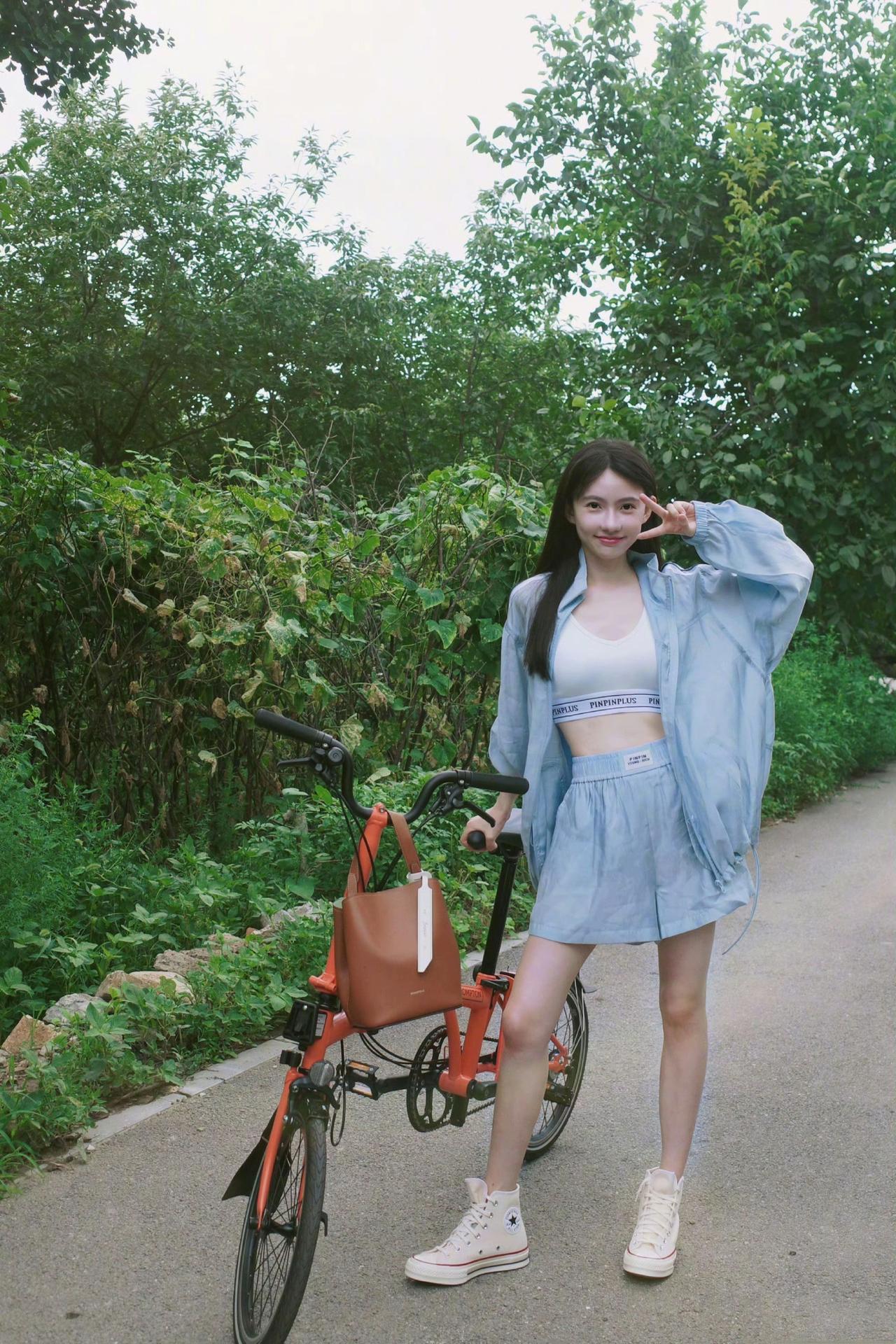 绿树阴中骑车行，春日微风拂面生。