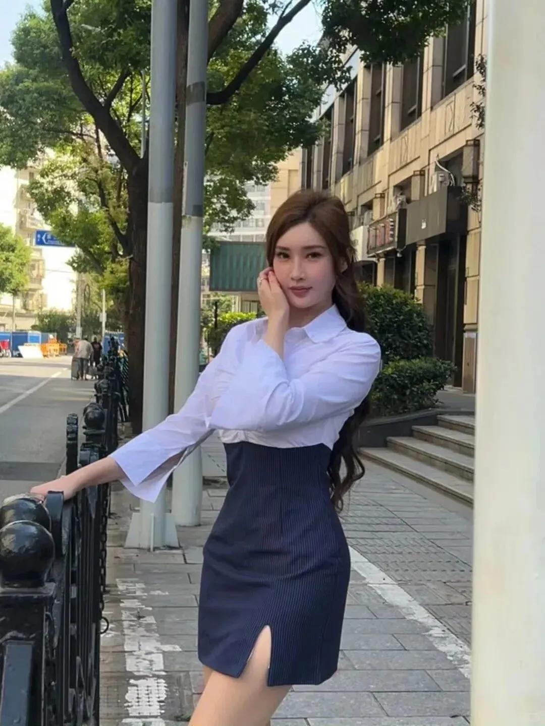 都市街景的喧嚣与她的职场穿搭相互交融——挺括的西装裙摆随步履轻扬，珍珠耳钉在晨光