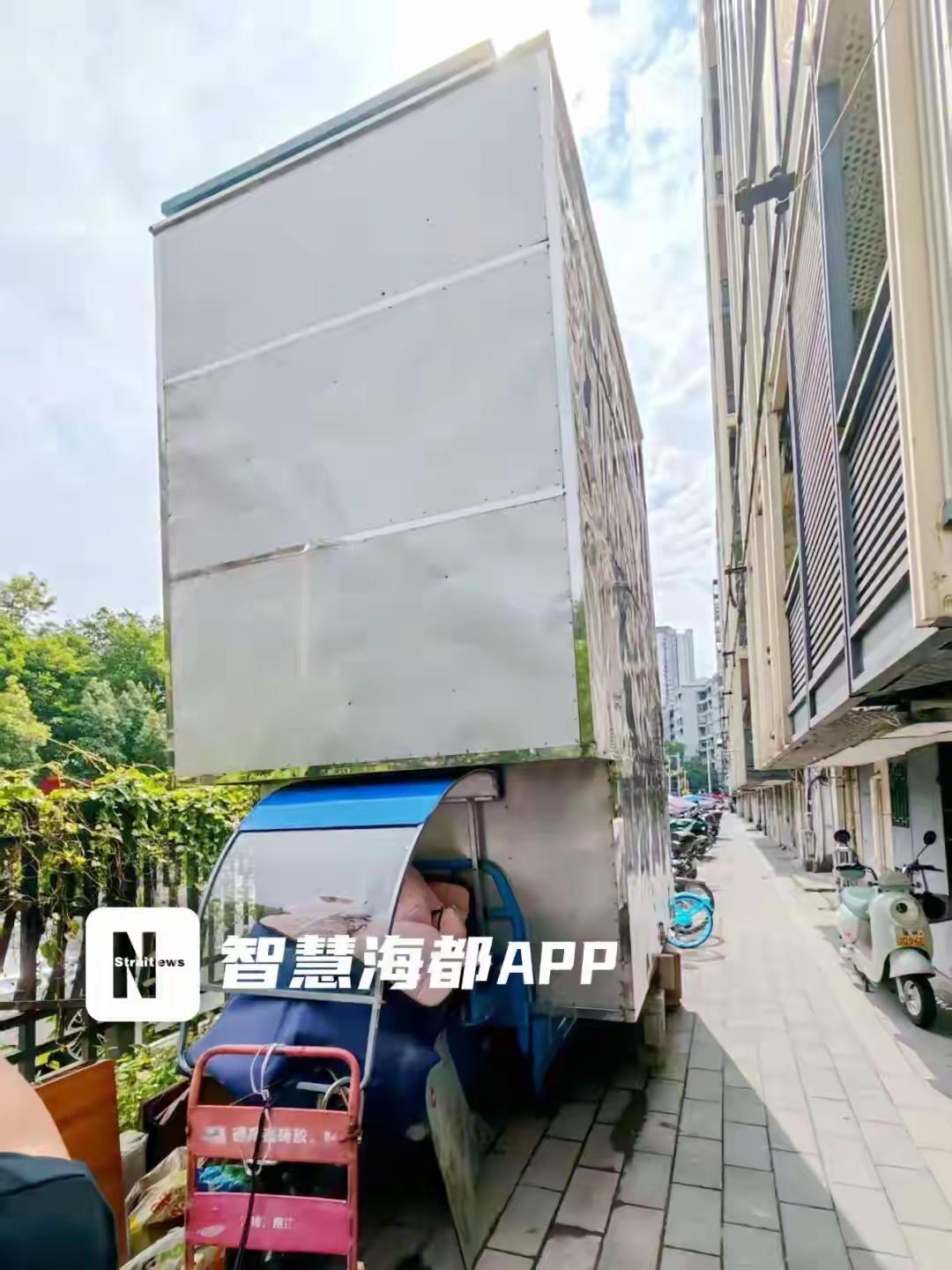 福州台江，一辆三轮车上垒起3米高铁皮仓库，长期停放在小区公共道路旁。三轮车影响出