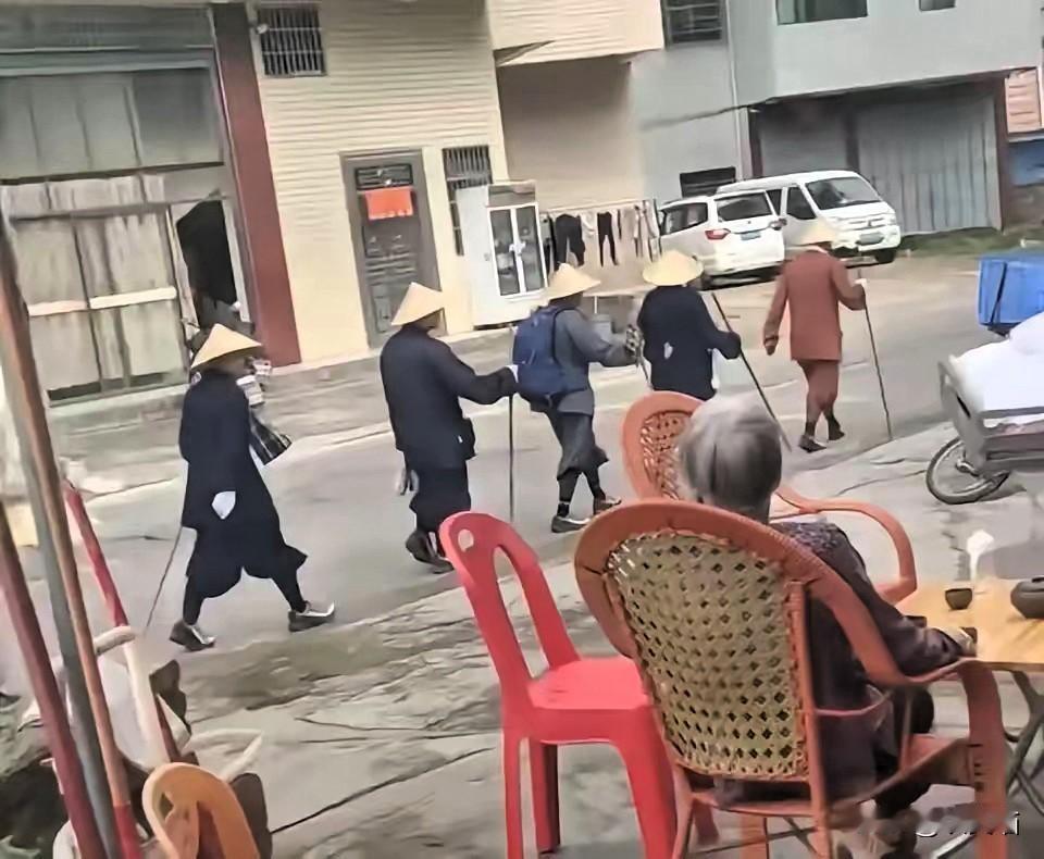广东梅州街头这一幕属实让人看呆了，
不少路人偶然撞见后都满心疑惑。一行人整齐排成