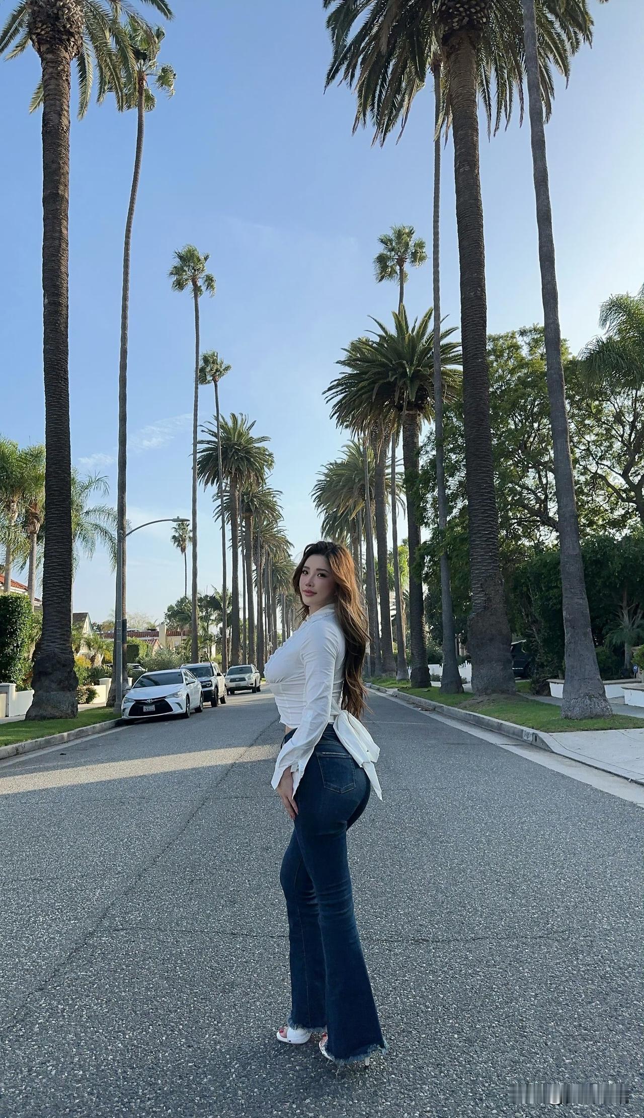 阳光明媚的街道上，时尚女孩与棕榈树相伴，尽显都市风情。