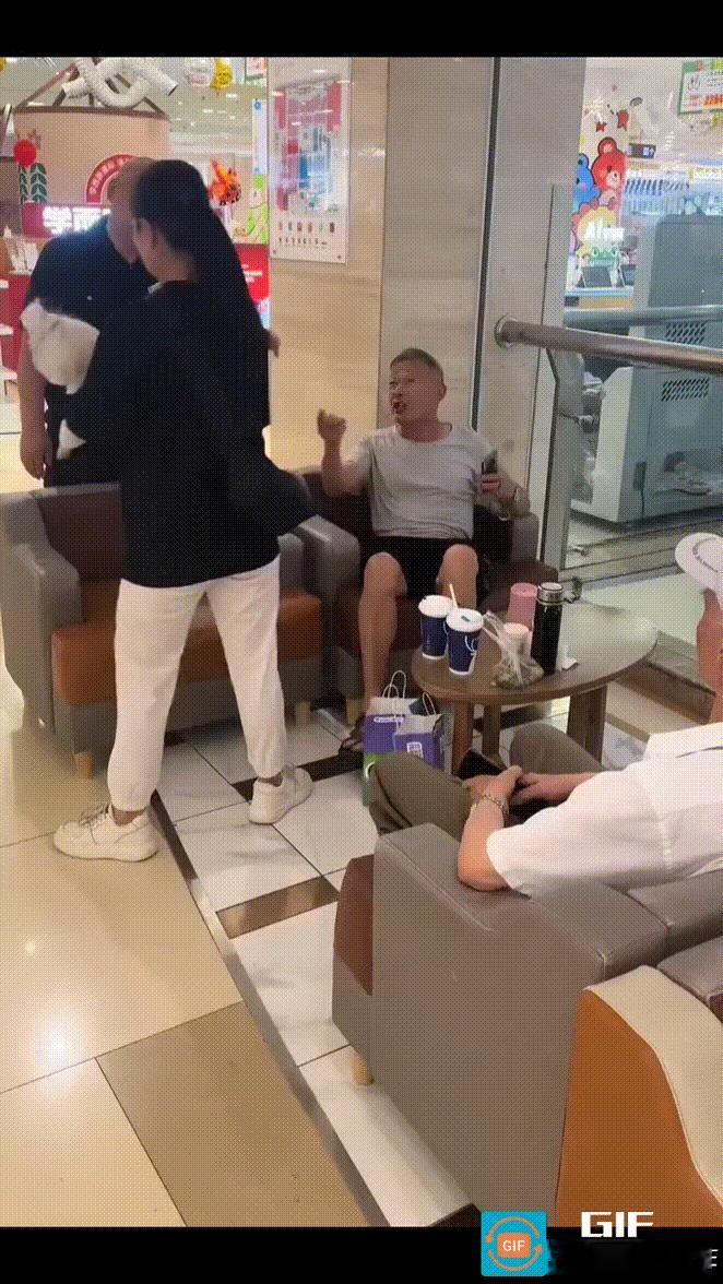 成都某商场中庭休息区，一年轻女子想将宠物狗放置在供顾客人歇脚的沙发上，被坐在旁边