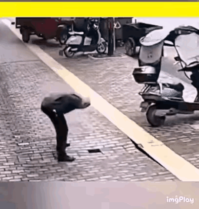 网友震惊了:一老人走在路上，看到一处路面塌陷，还有一个洞，老人很惊讶低头往洞里瞅