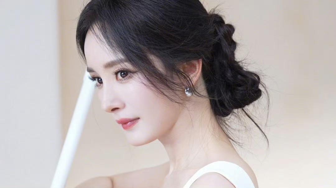 一袭纯白吊带裙，低盘发散落几缕碎发，温柔氛围感直接拉满✨
优雅从容是她，灵动俏皮