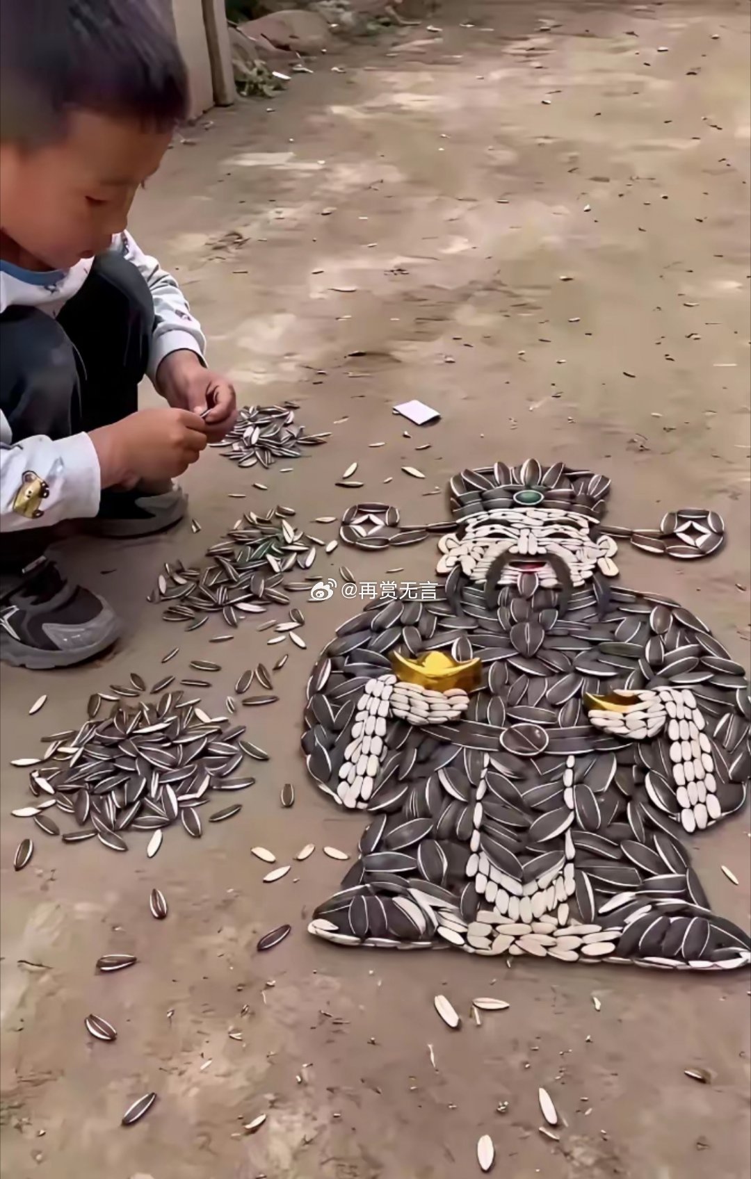 孩子年龄不大，能用葵花籽在地上拼出财神爷，构图准确，造型稳重，色彩亮丽，绝对是搞