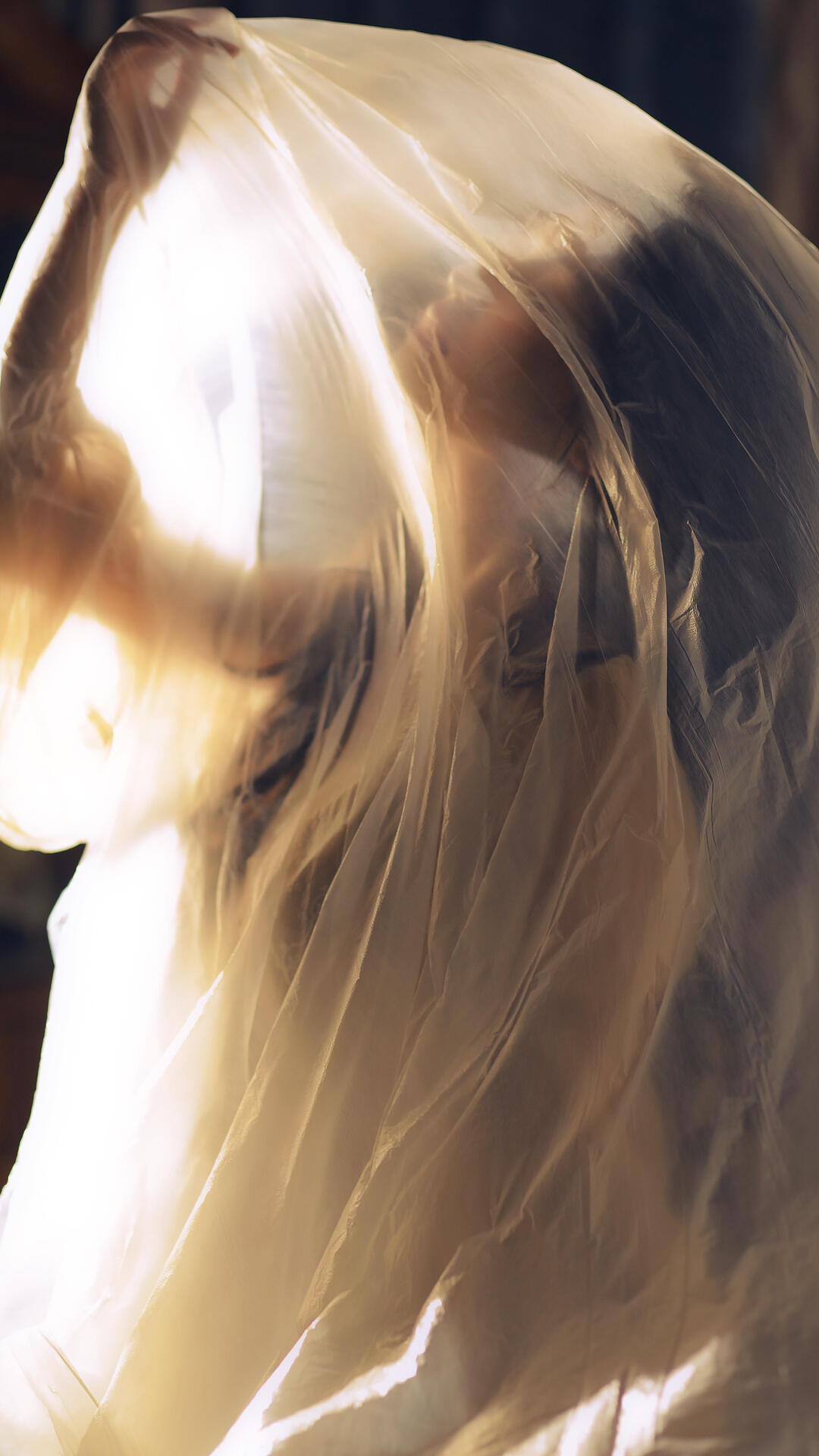 逆光里照片以“光的逃逸”打破了前几张的压抑，却让束缚感更显尖锐。模特的侧脸被逆光