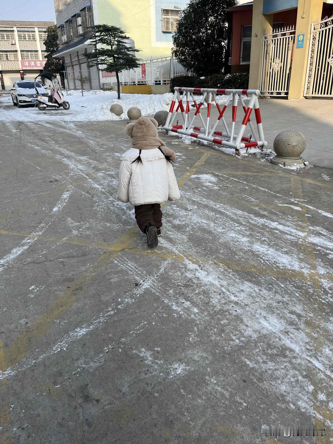雪刚化了大半，小区空地上还留着白花花的残雪。刚给娃裹上厚棉袄，她就颠颠儿往门外跑