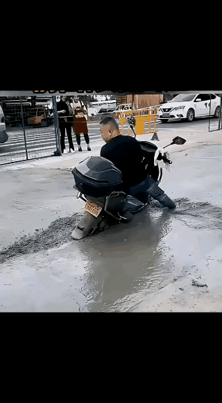 这个大哥还这么磨蹭干啥？
      赶紧给钱请几个有力气的人把摩托车抬出来，然