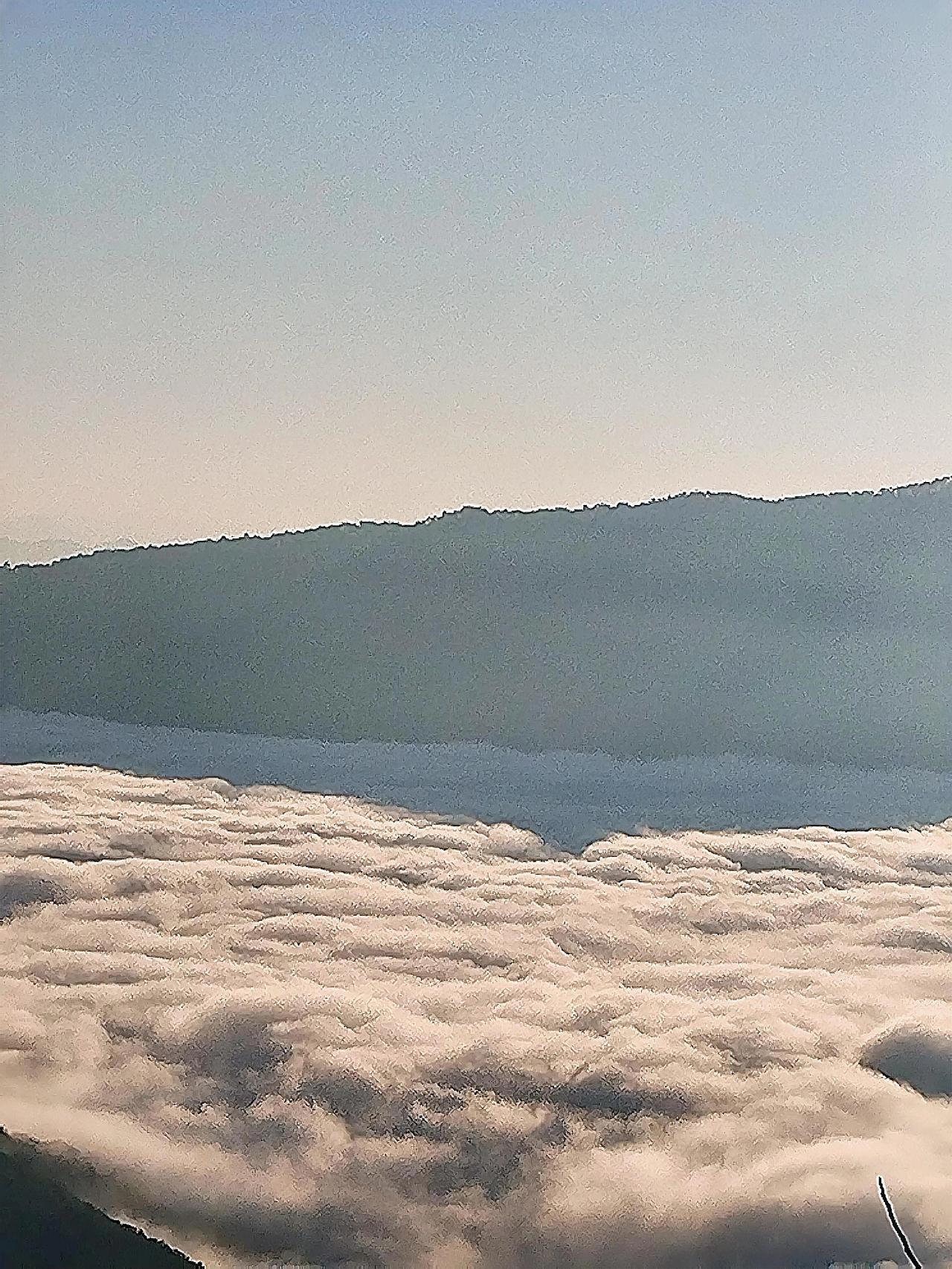 云海翻涌，山峦隐隐绰绰。在这如诗如梦的云海间，阳光穿透云层罅隙，洒下一道道金色光