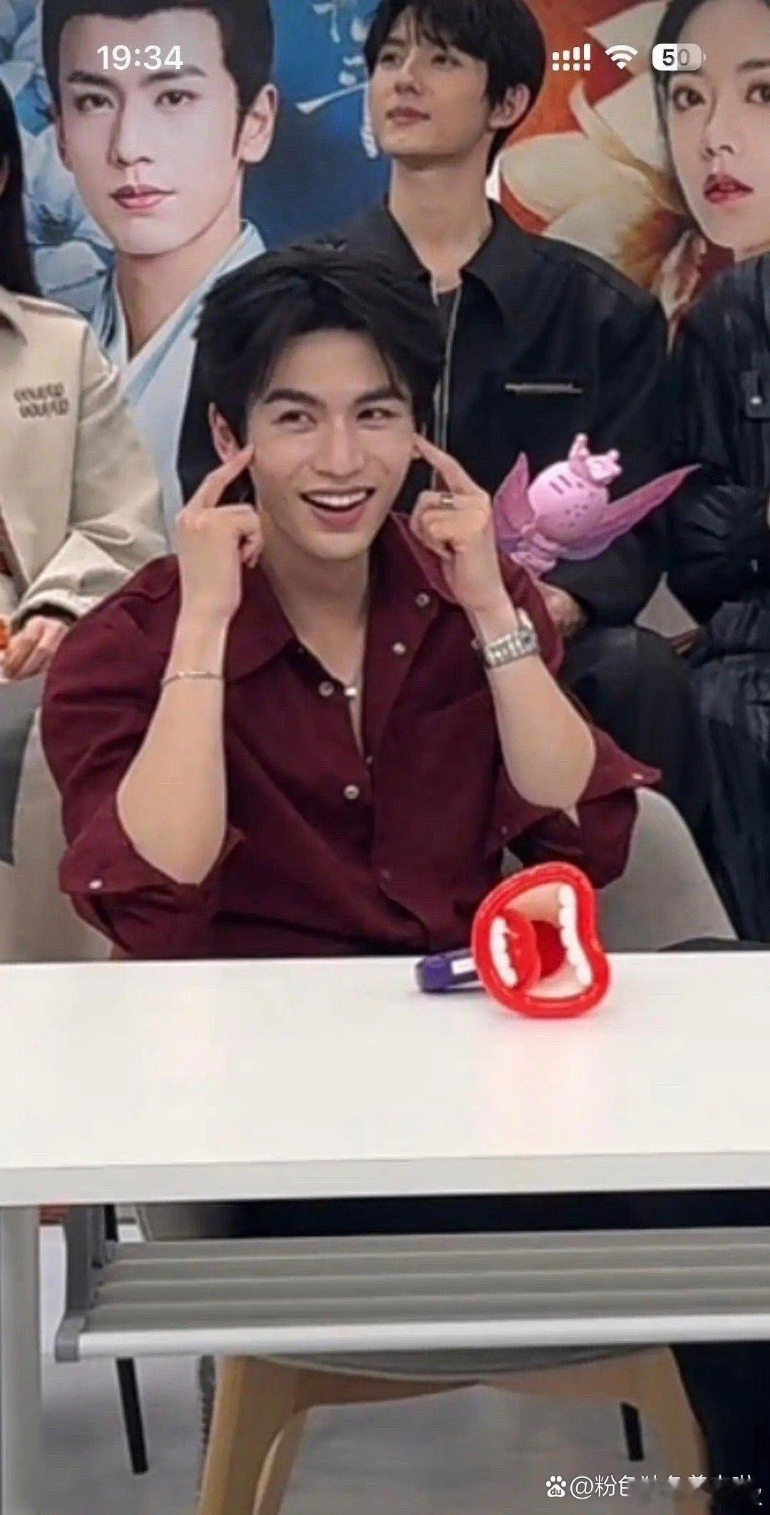 张凌赫担心衣服褶皱会散开，所以用手按着 