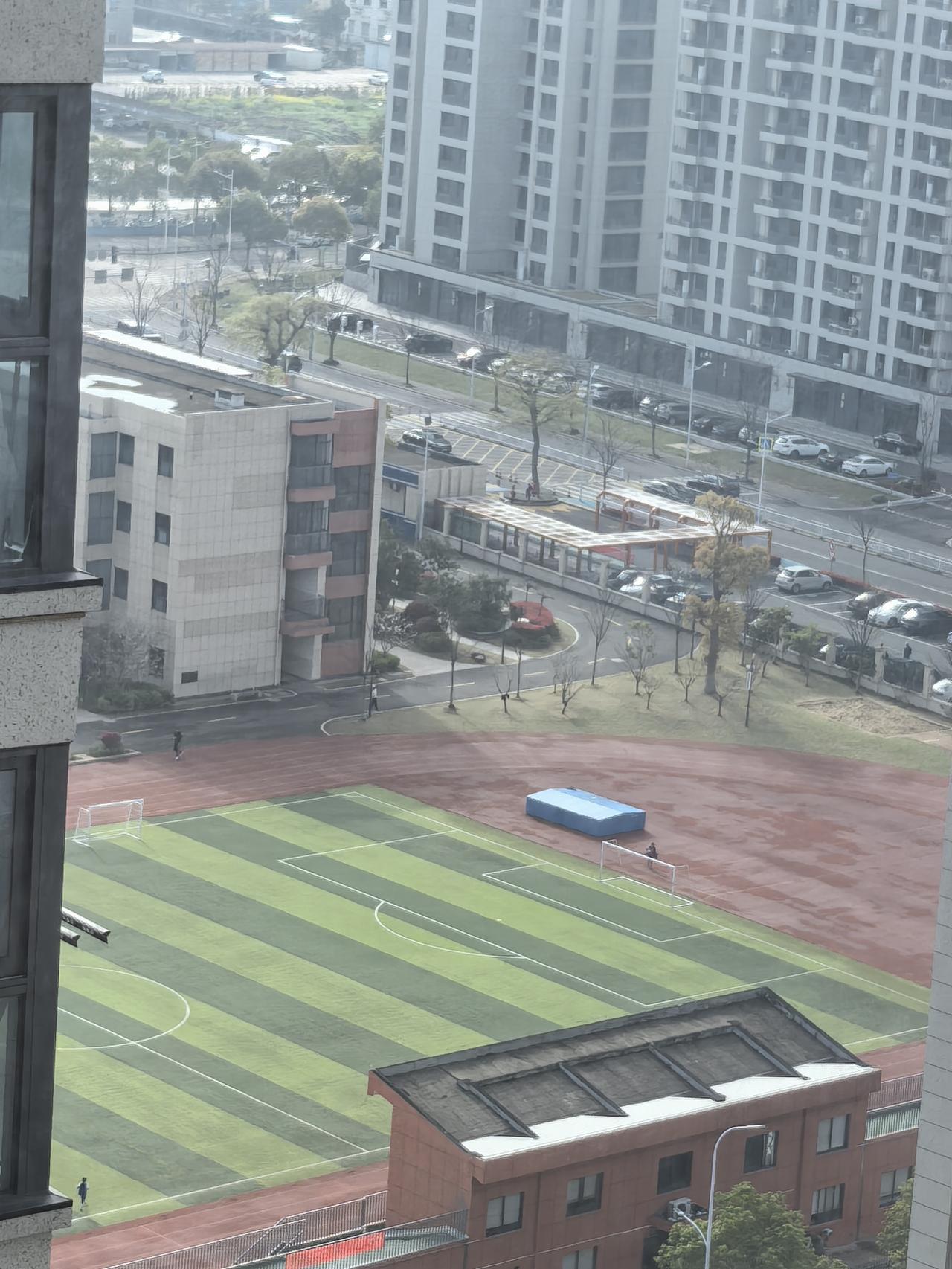 天放晴了，从婆婆家窗望出去，看到马路对面的小学操场有人在跑步，有人在踢足球，蓝天