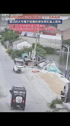 江苏徐州一名男子家门前的空地上，晾晒着刚收割完的小麦。天色突然沉了下来，雨意来得
