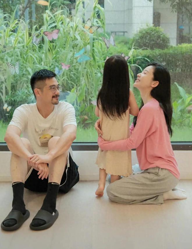 杨子姗罕见分享一家三口温馨照片，捉蝴蝶画面简约温馨。吴中天父爱满满，默默守护女儿