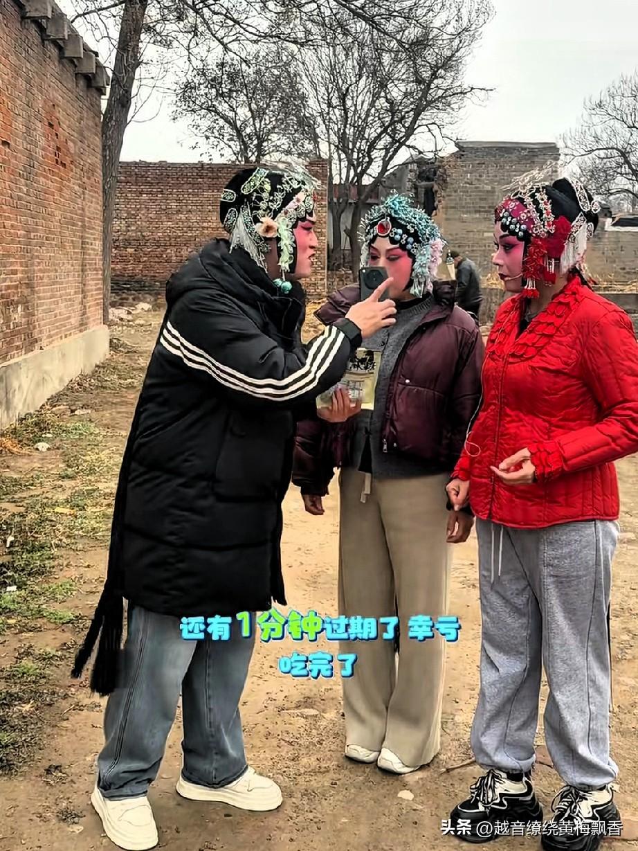 这些戏曲演员利用候场时间还在一起分享零食，台上的人唱声余音缭绕，台下的人吃的是欢