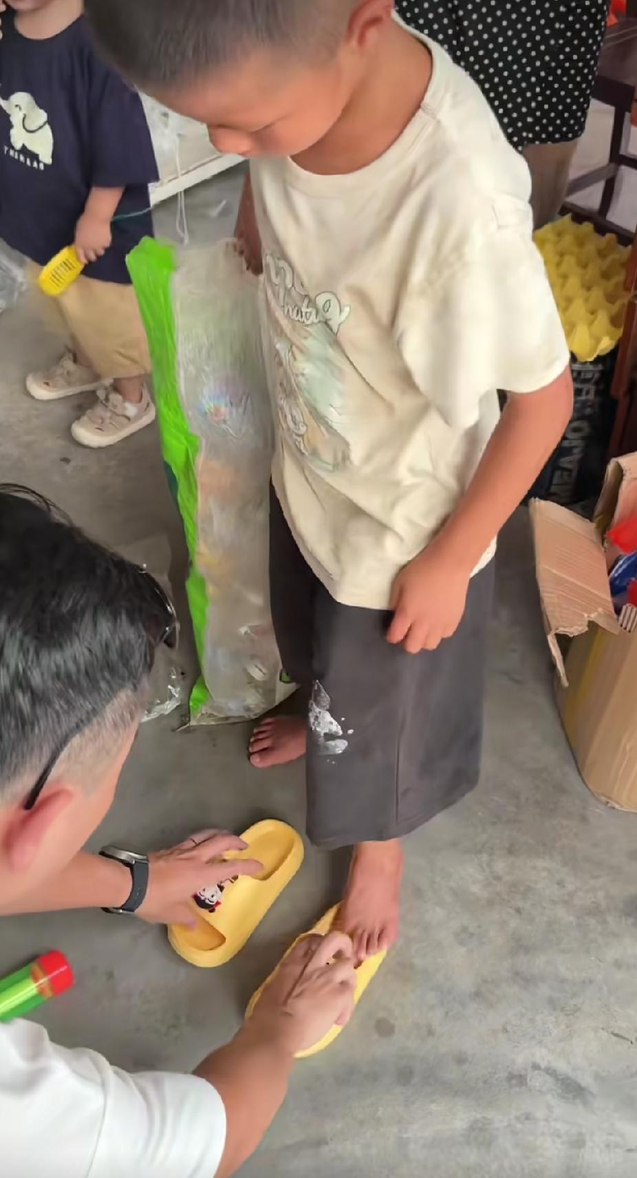 一对小夫妻带着自己的女儿，去景区里玩。看到一个拾荒小男孩的脚时，小女孩的爸爸做了