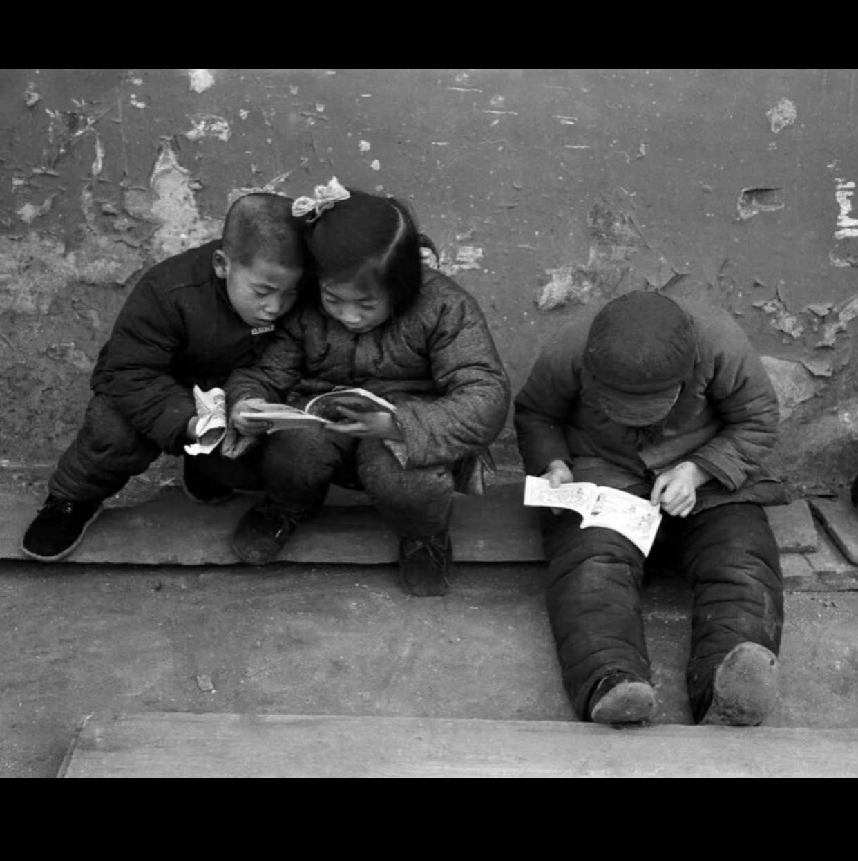 寒冬里的温暖时光，三个孩子依偎在一起，共享书本的乐趣。相信大家都有这种美好回忆吧