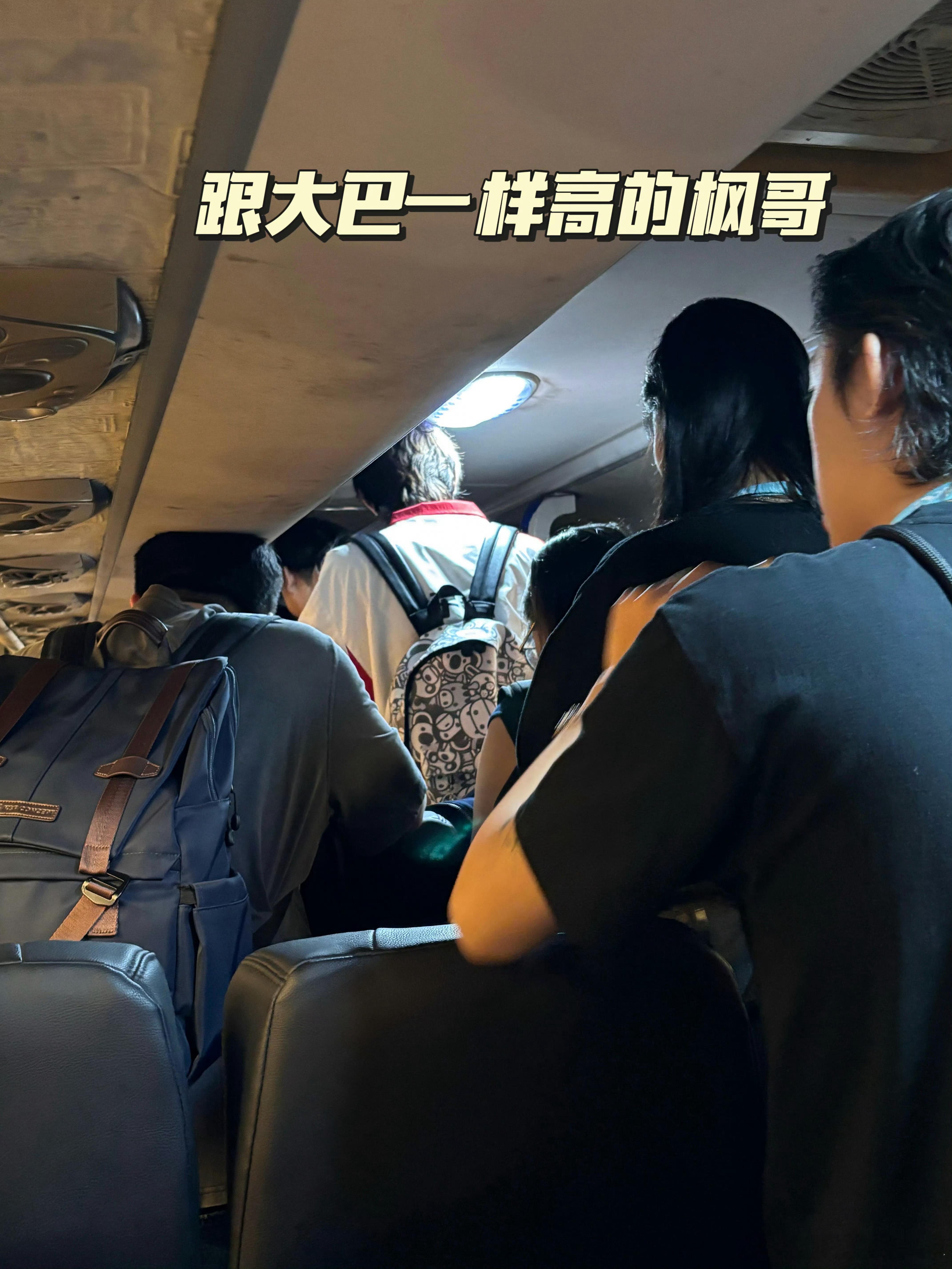 AG子枫ovo 190cm身高在大巴内与车顶形成强烈对比，画面显示其需低头行进。