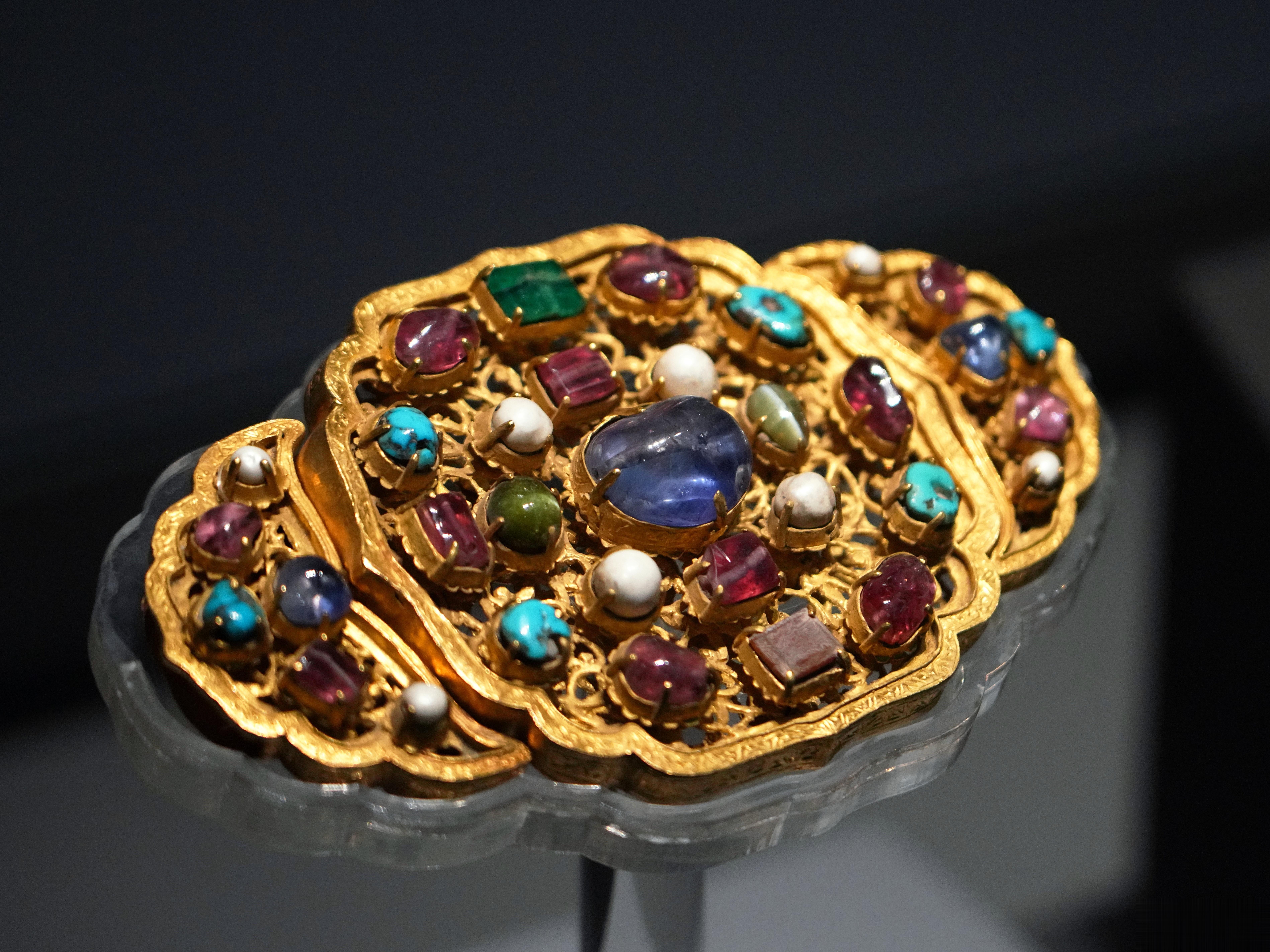 山东省博物馆镶宝石金带饰明洪武遗存，邹城明鲁王朱檀墓出土。带饰为如意云形，托体金