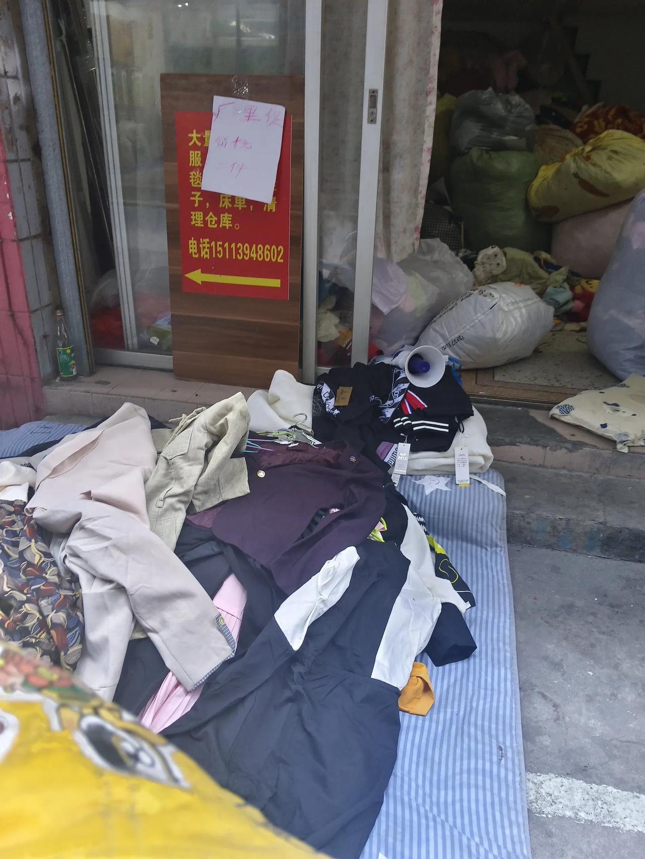 今天上午去给卖鱼小弟送冰，路过一个回收旧衣服的店铺，看里面收的旧衣服一大包一大包