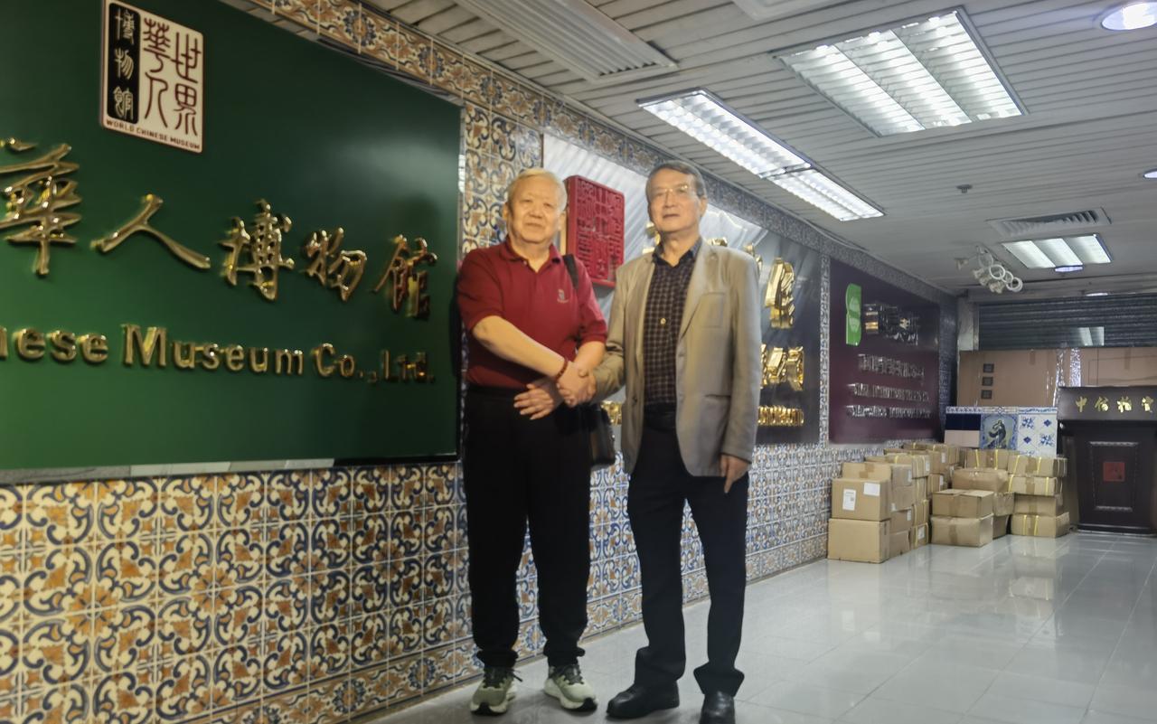 两个馆长相见恨晚
穿短袖红T恤衫的是《海南博物馆》馆长韩福山先生；戴眼镜的是《华