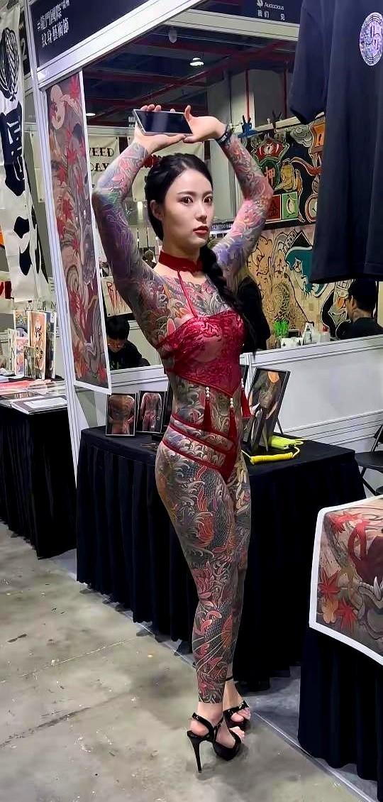 社交平台最近炸出一组照片，一位二十出头的姑娘把肩膀到脚踝都覆满墨绿色纹身，自称“