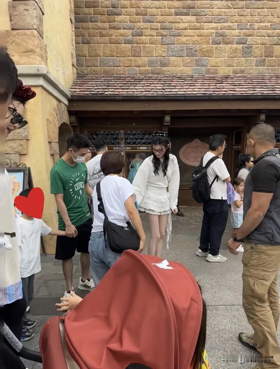 奚梦瑶和老公带着两个孩子和助理、保姆现身香港迪士尼。奚梦瑶戴着眼镜，穿着一身短裙