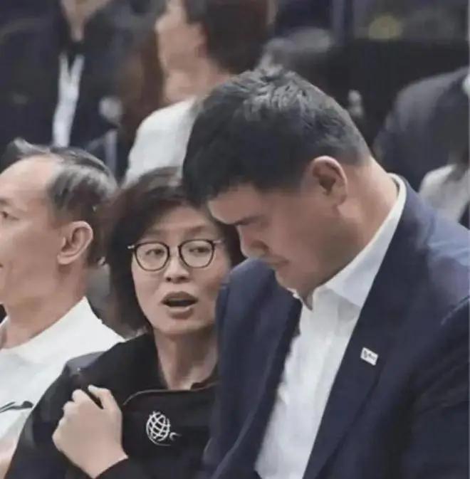 图里这位女士是姚明的妻子叶莉，这个表情有几层解读：
神态细节：眼睛斜着瞟向低头写
