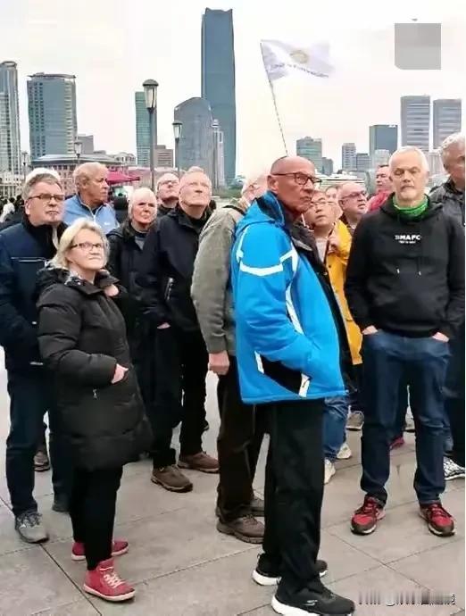这张照片让人深思，上海外滩，一群老外来中国旅游，他们的表情凝重，根本就看不到旅游