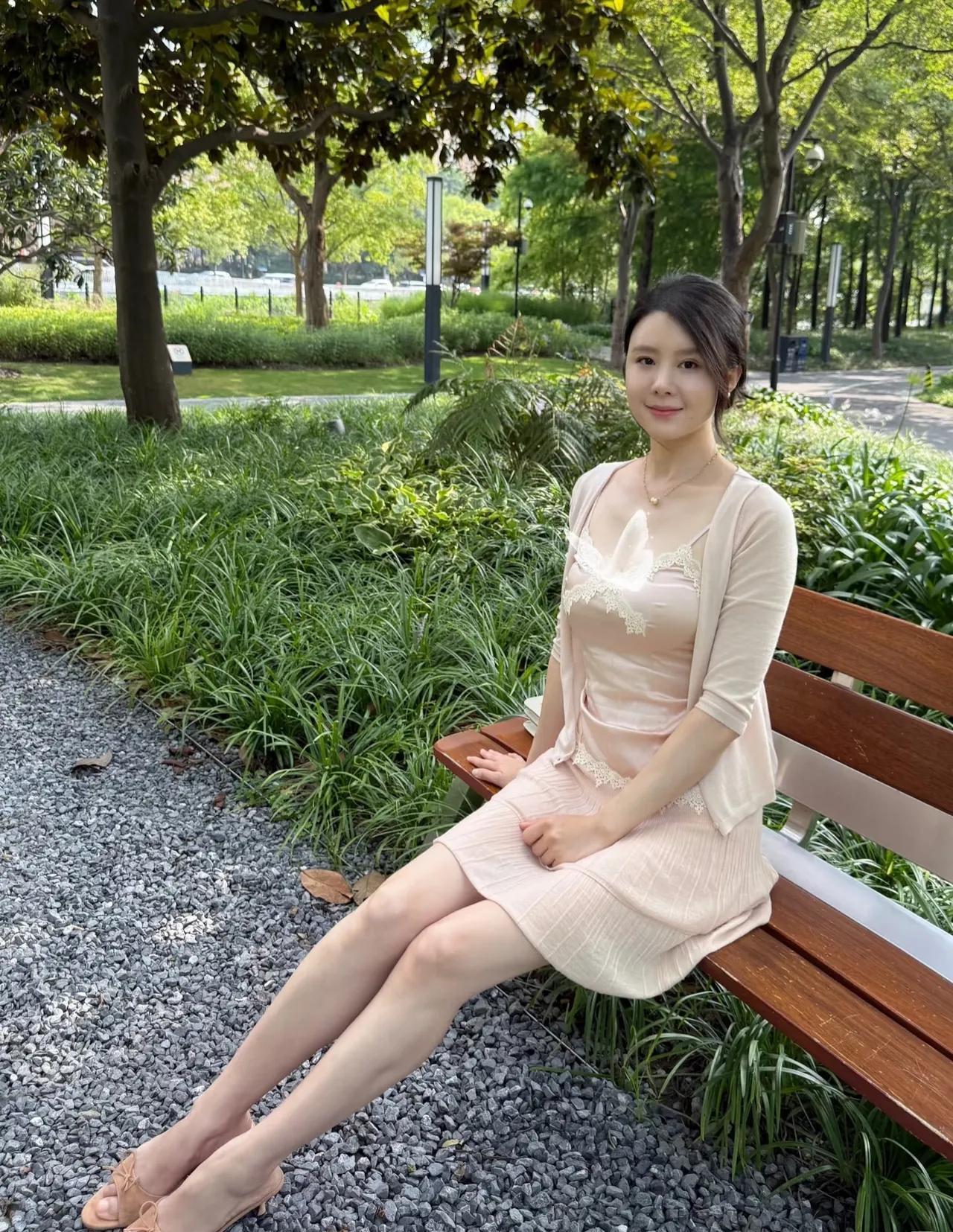 夏日清新穿搭，粉色连衣裙搭配米色开衫，坐在公园长椅上，享受宁静时光。