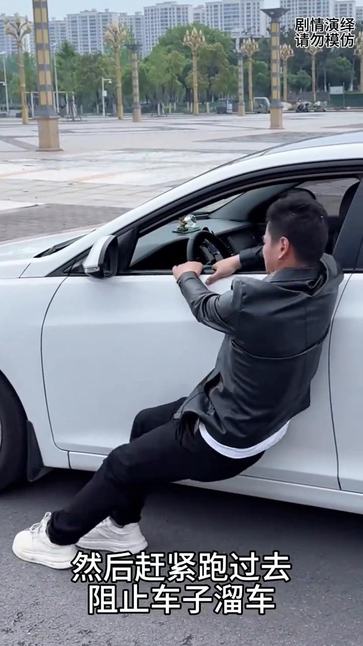 男子看到车子溜车去阻止，谁知他却帮了倒忙。
男子看到路上车子在溜车，于是他扔掉身
