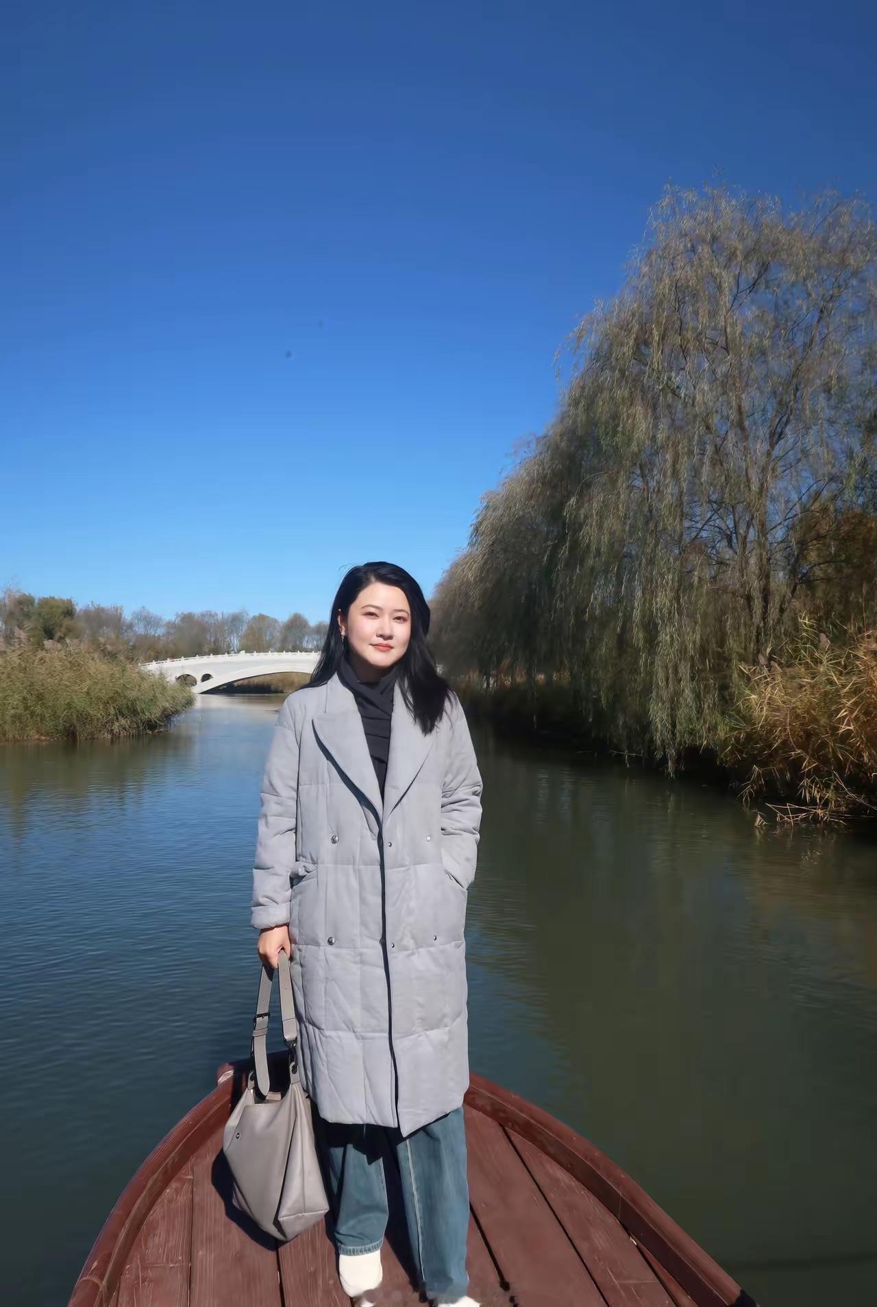 一个人站在河边，看着风景。