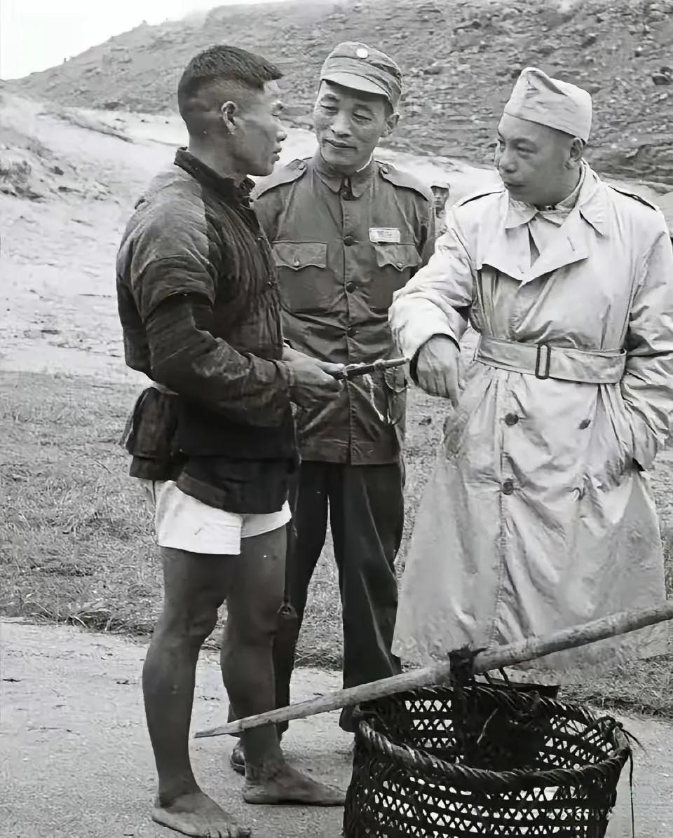 奇怪指数很高的蒋家二代视察海岛图。
其一，他的穿着，风衣尚可理解，这帽子显得不伦