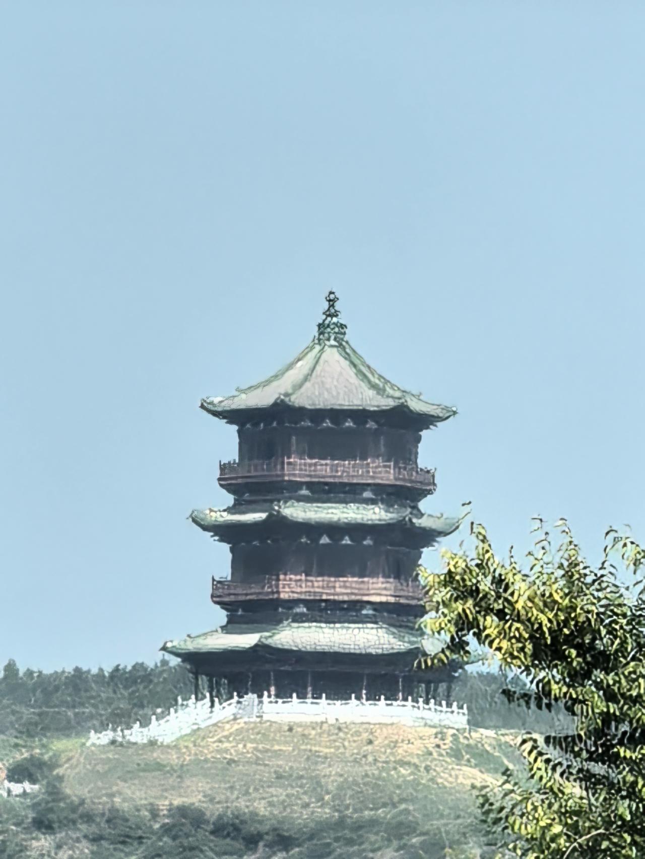 这是一座古老的塔，立在山顶上，蓝天白云衬着，格外醒目！