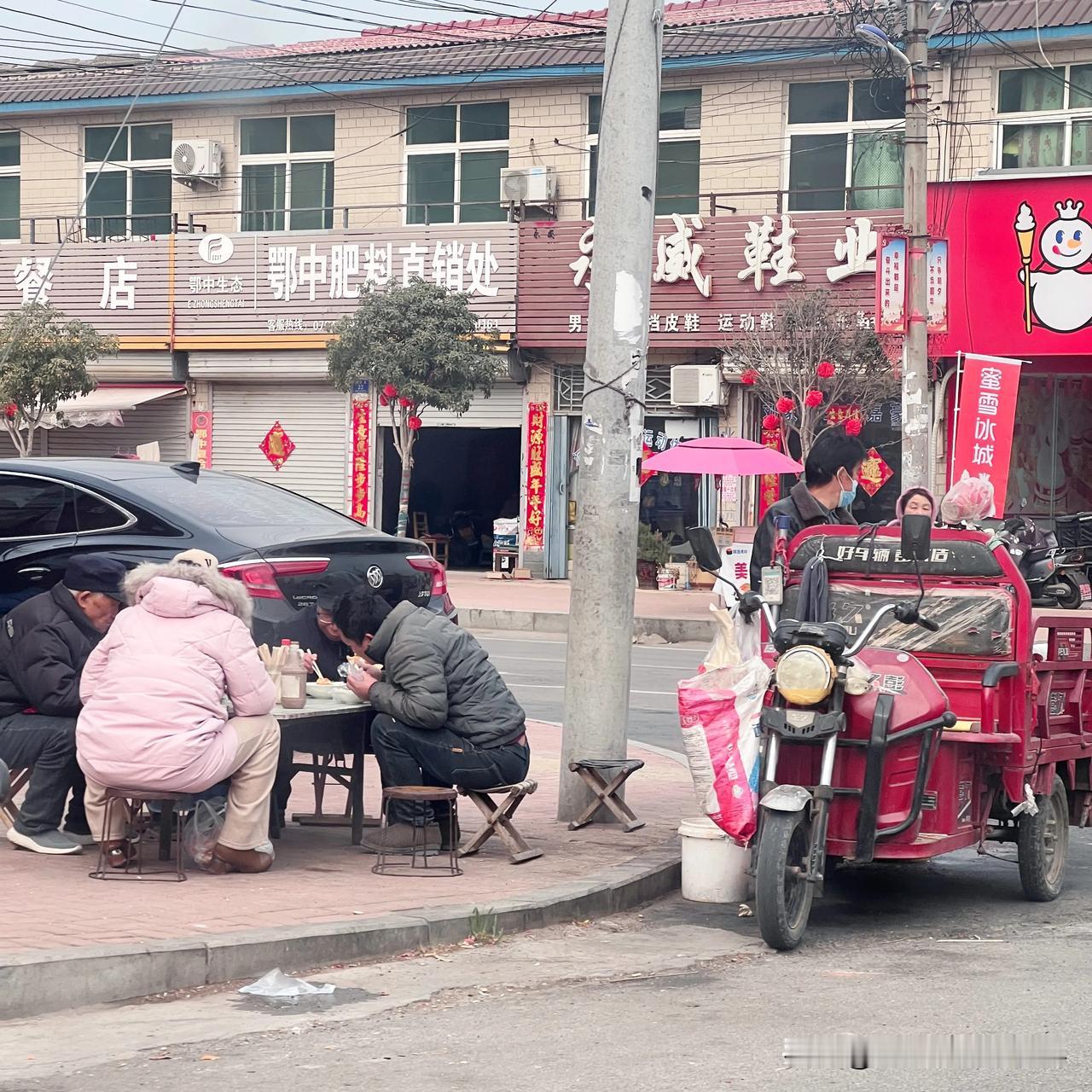 叶县龙泉，人们围在街头桌子旁吃热豆腐，热豆腐在叶县、舞钢、舞阳很是流行。传统的热