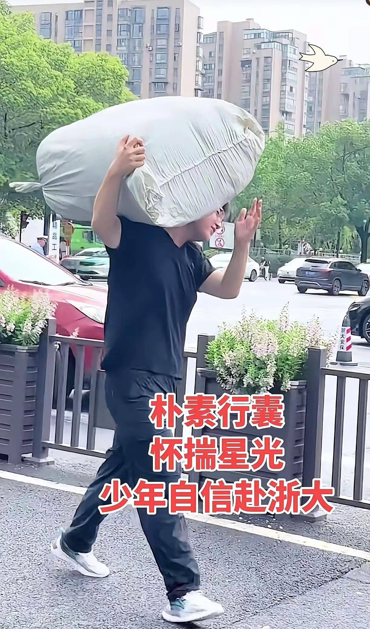 浙大新生入学一幕，让人看完心生感慨。这名来自哈尔滨的高大男生，独自扛着鼓鼓的蛇皮