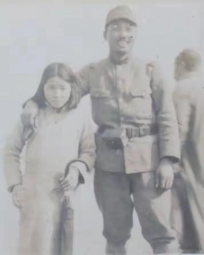 1938年的南京街头，一名日军士兵拦住过路的女孩，强行与她合影。鬼子肆无忌惮地将