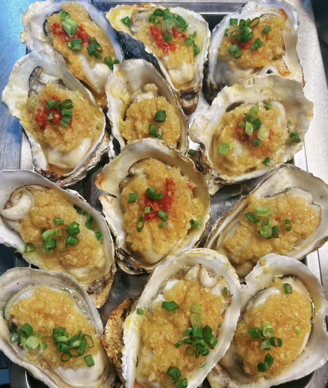 刚端上桌就被这盘蒜蓉烤生蚝香迷糊了！
 
金黄的蒜蓉铺满饱满的蚝肉，高温烤得蒜香