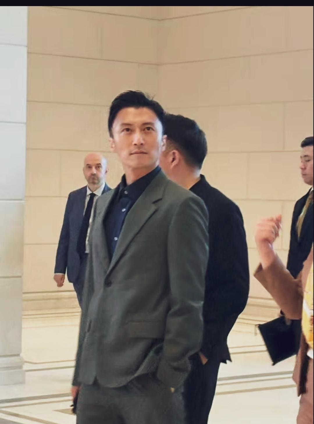 一身简雅西装，手插口袋，神情沉静，举手投足尽显成熟利落的气场。