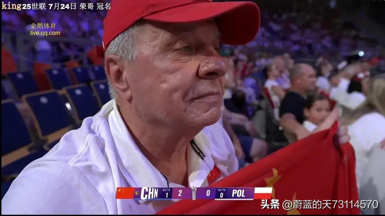 世联赛四分之一决赛中国女排对战东道主波兰女排。屏上又看见了头戴小红帽，手拿中国国