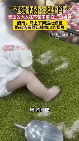7月13日，江苏扬州，一位家长把穿着纸尿裤的孩子放在超市的绿豆架上，自己则在旁边