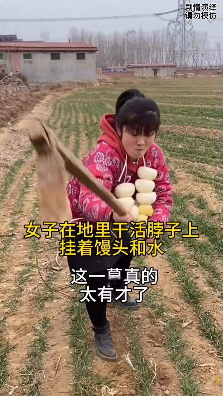 女子在地里锄地，只见她脖子上挂着馒头和水。这时女子饿了，就吃馒头，然后坐下喝口水