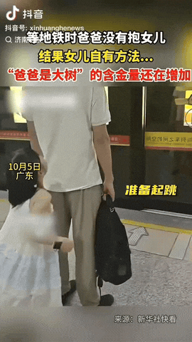 广东，一男子在等地铁时没空抱女儿，没想到女儿用自己的方法爬到了爸爸肩头，不到十五