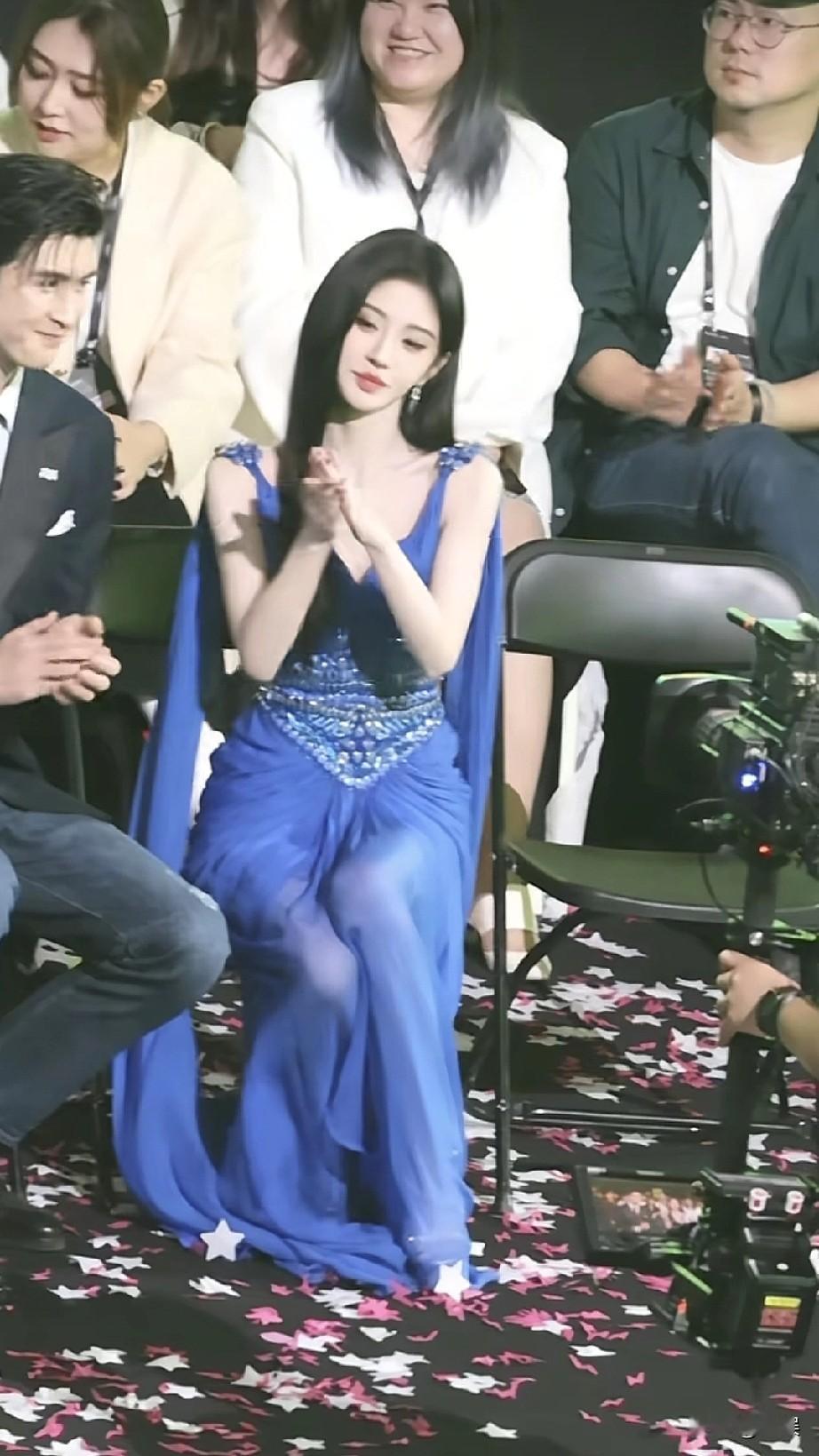 在活动现场，鞠婧祎身着一袭蓝色的华丽晚礼服，精致的亮片装饰与轻盈的裙摆相得益彰