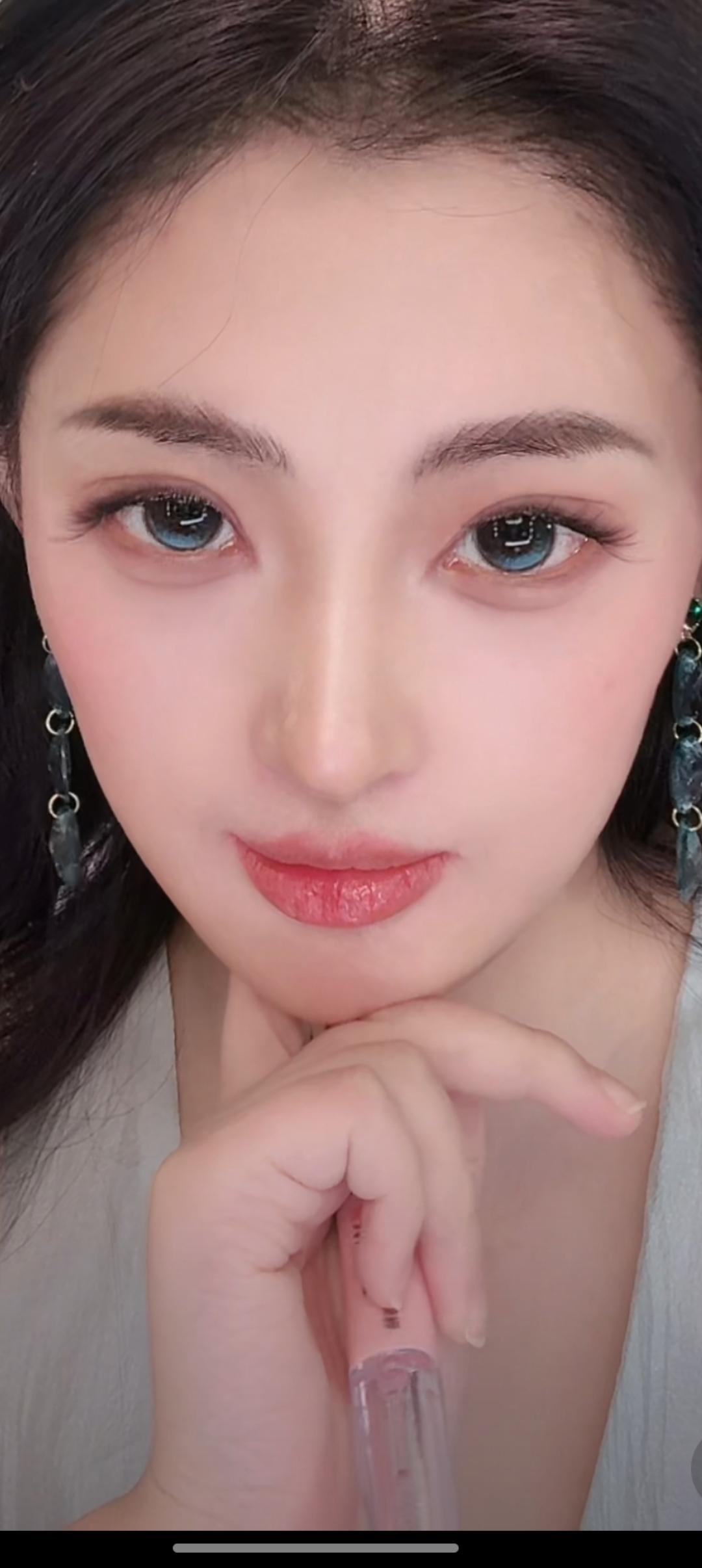 这个女生在思考，看着镜头。