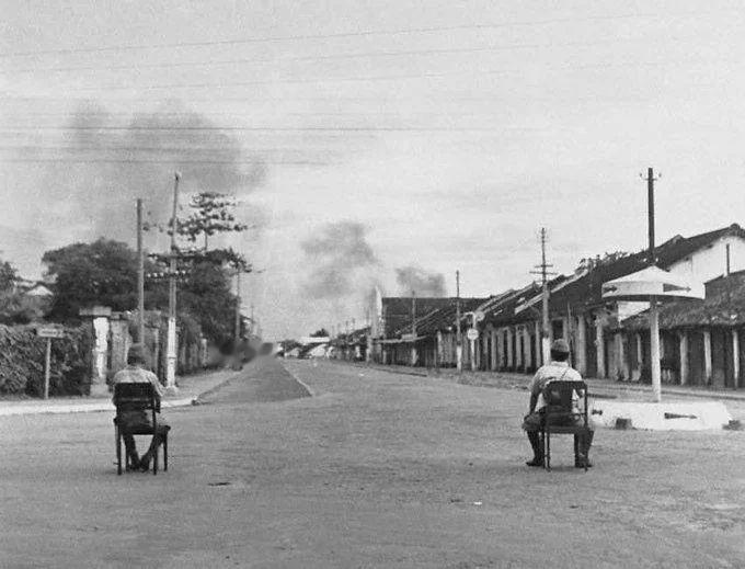 1945 年 10 月 17 日 , 日军士兵在西贡围观法军与越盟军队之间的战斗