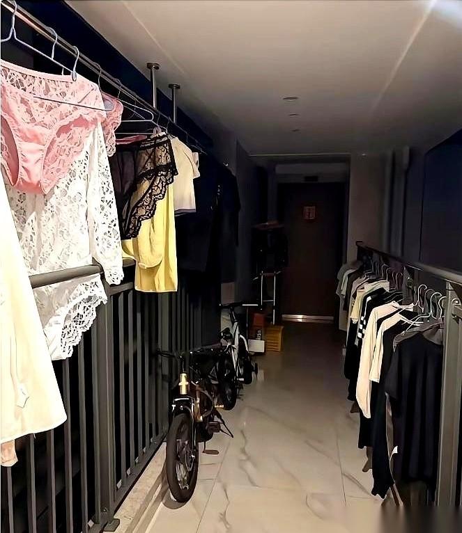 刚拐进我们这栋楼的连廊，那股熟悉的浓香又撞了过来。
又是她。一整排湿漉漉的衣服，