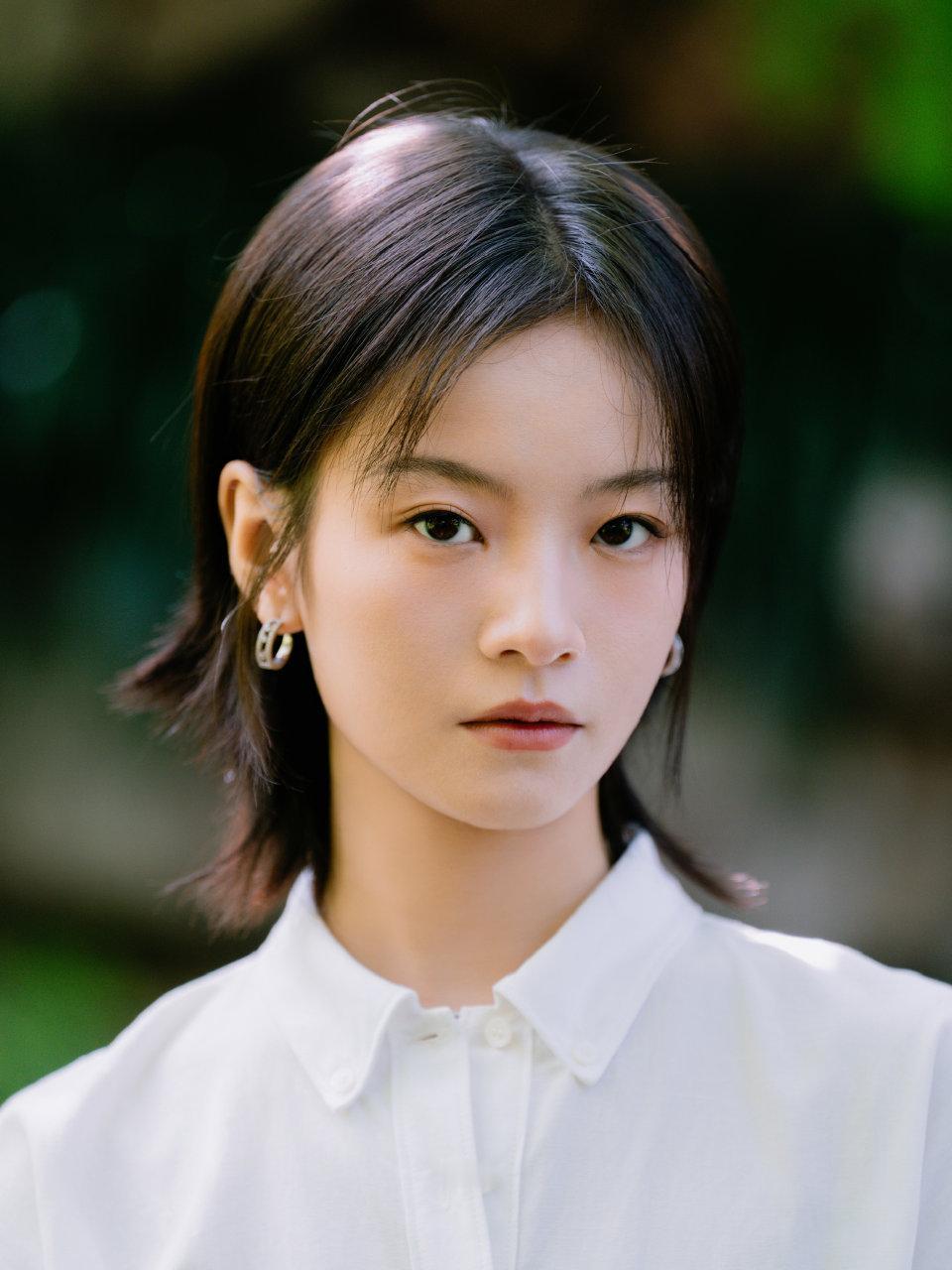李庚希的一组充满绿意的街拍写真，展现李庚希清新自然的青春形象。

她身穿白色连衣