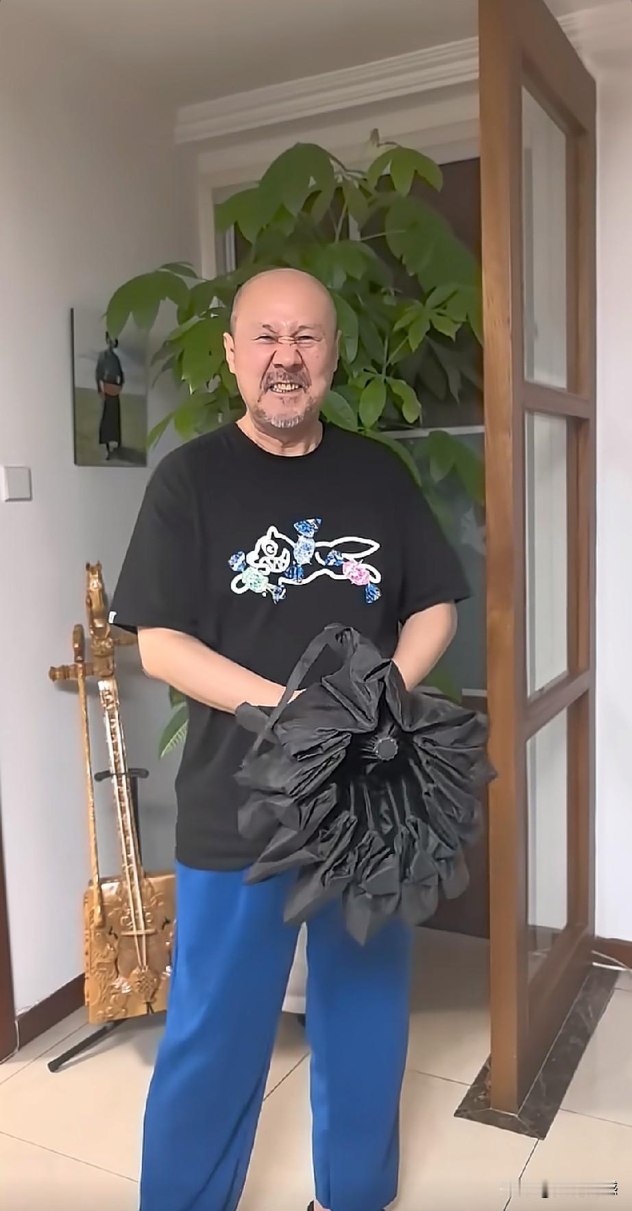 腾格尔老师对伞还是比较有研究的，他拿出了一把伞，突然以迅雷不及掩耳之势，一瞬间就