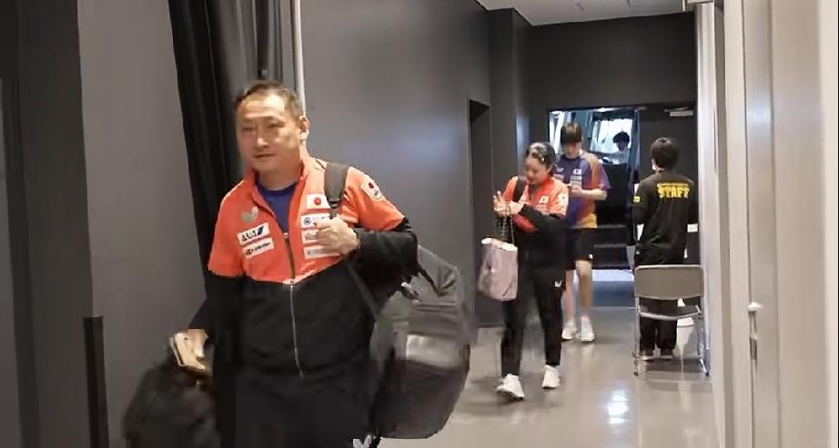 张本宇带着兄妹俩从后台走过。
张本智和，张本美和俩人都背着包，后台遇到记者张本美