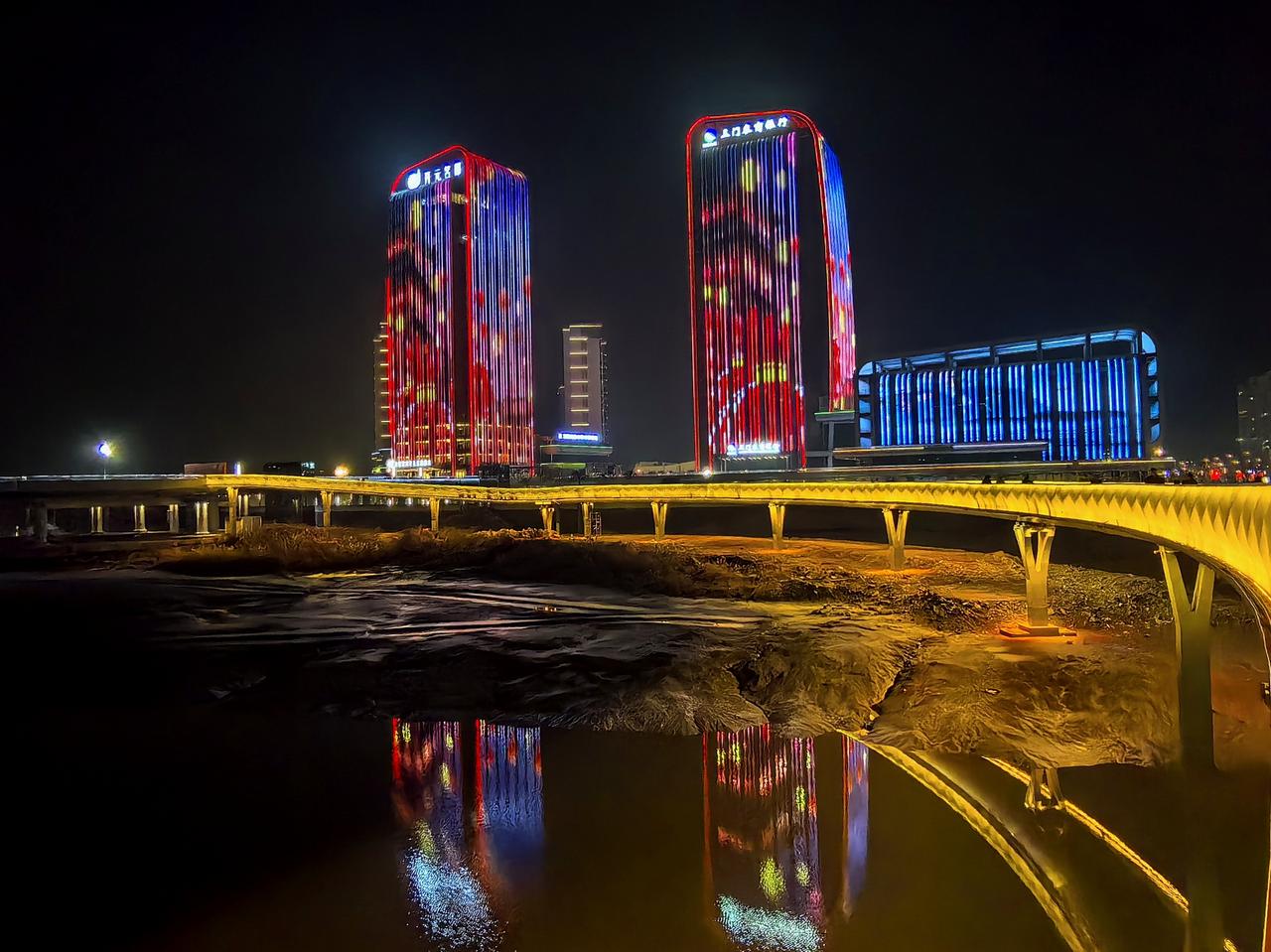 七律·夜登三门城市阳台
谁裁彩锦覆三江，
夜上层台听土腔。
六里云桥浮玉练，
一